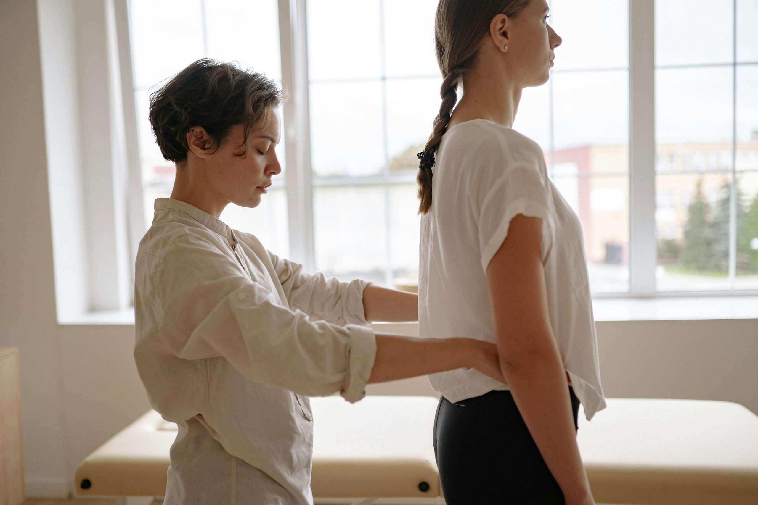 Physiotherapist supporting a woman experiencing pelvic pain during women’s health physiotherapy treatment.